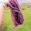 a hand holding a purple yarn
