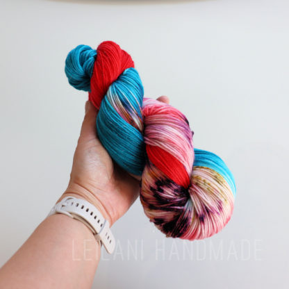 a hand holding a colorful yarn