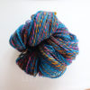 Close-up image of a skein of yarn featuring vibrant colors including blue, pink, yellow, and orange. Set against a plain white background.