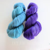 two skeins of handspun bfl yarn in blue and pruple