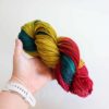 a hand holding a colorful yarn