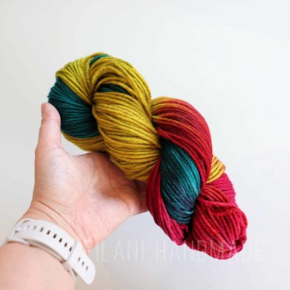 a hand holding a colorful yarn