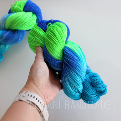a hand holding a skein of yarn