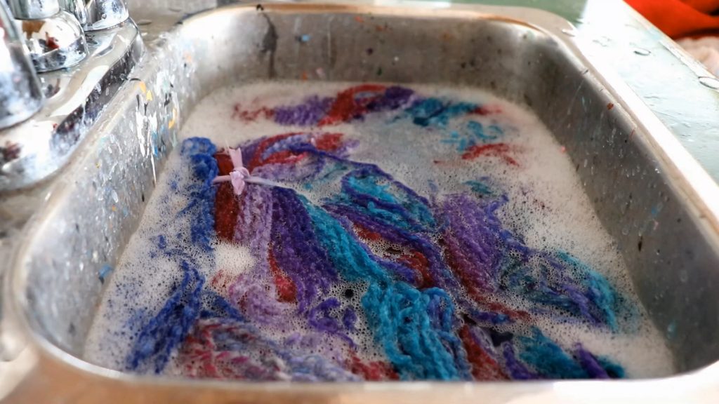 a sink of soapy water soaking handspun yarn