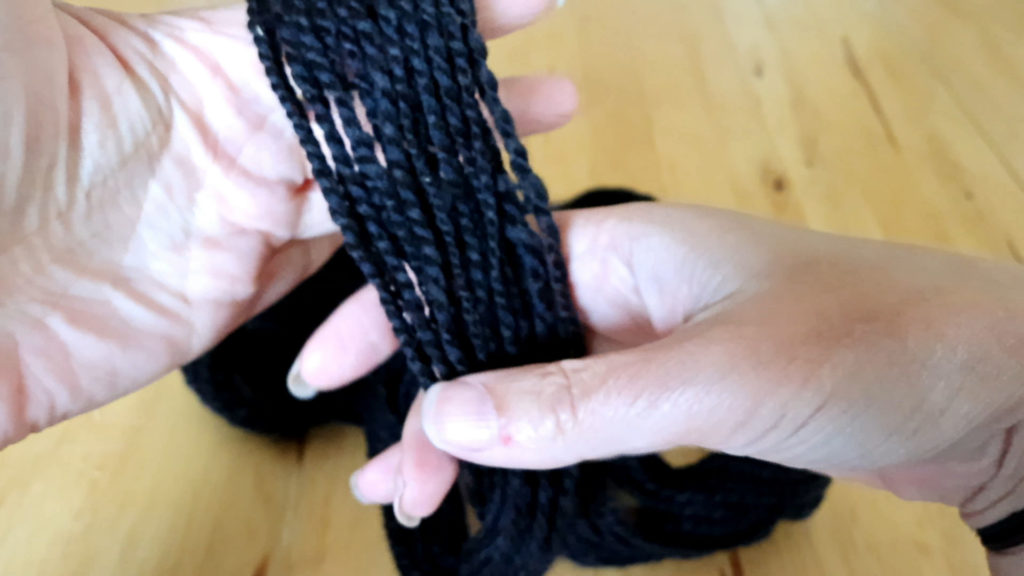 a person holding a bundle of black yarn